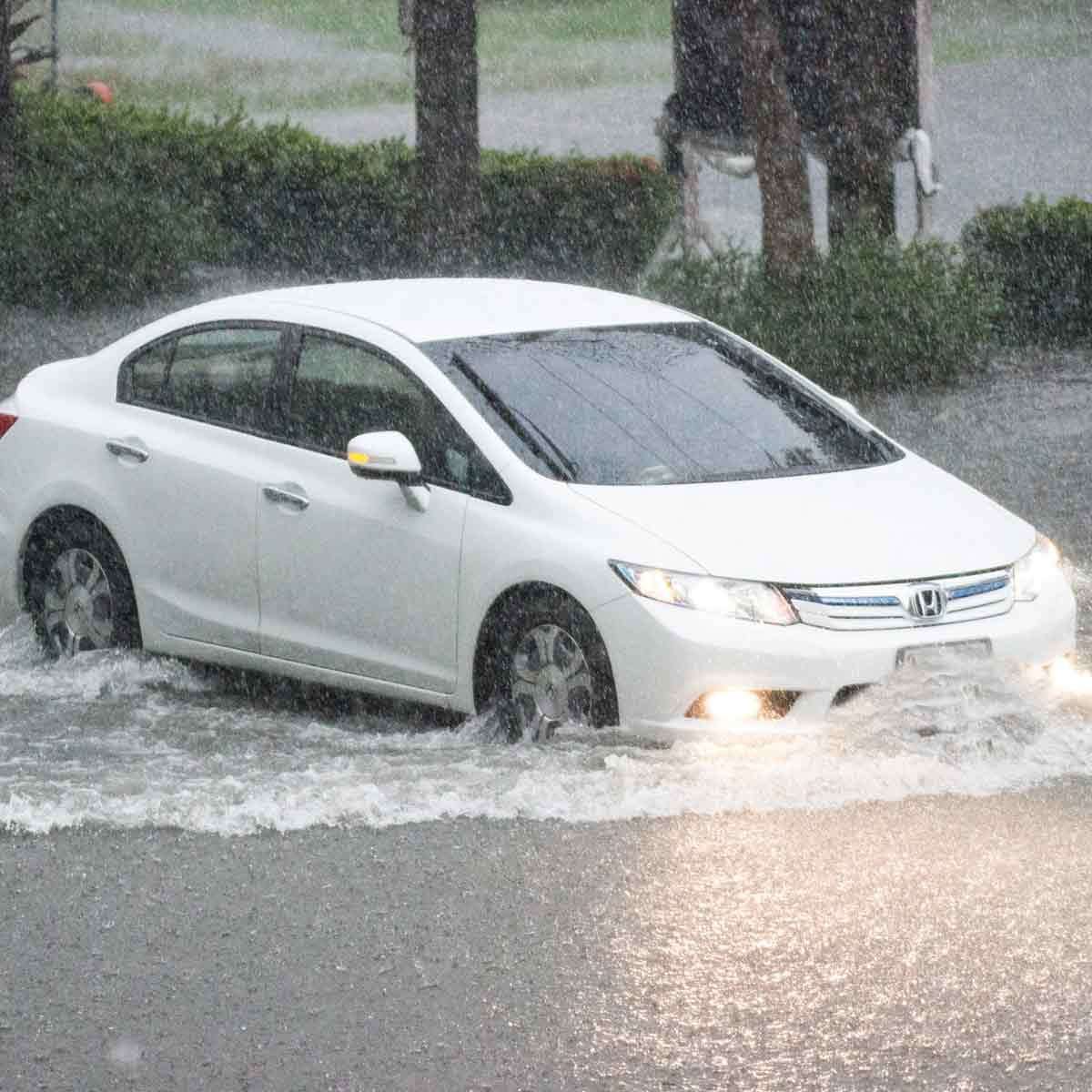 1675944425 car drives through flooded street shutterstock 1178292835