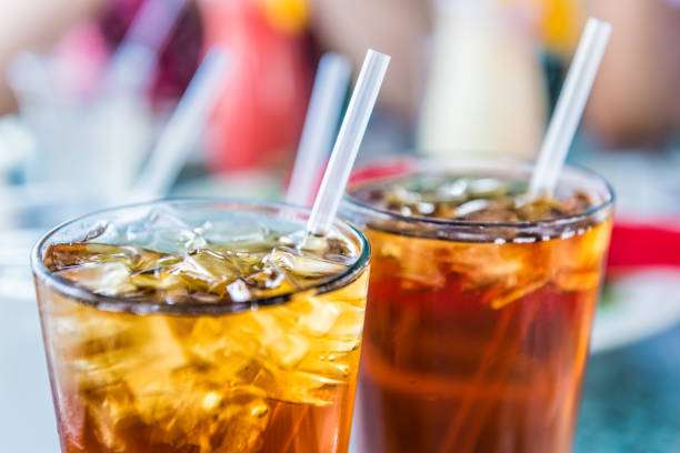 1684230665 macro closeup of iced tea or soda with ice cubes and straw in glass