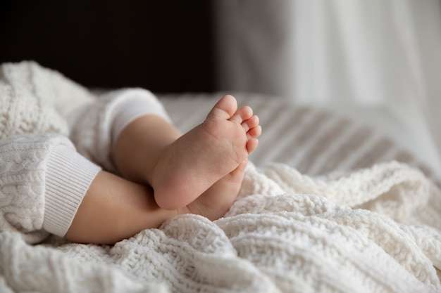 1687844776 cute baby girl legs white blanket natural light selective focus 146099 401