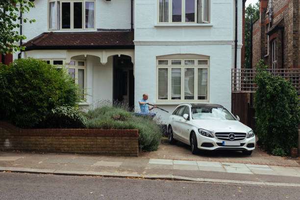1688188968 man washing his car in front of his house